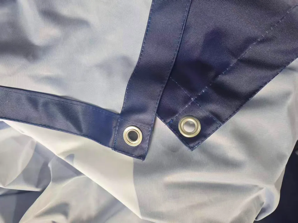 Reinforced blue banner edges with metal grommets for secure fence installation