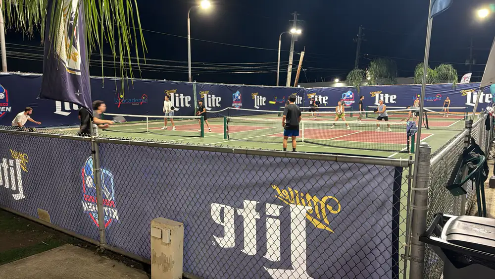 Oversized custom banners installed along a pickleball court perimeter fence