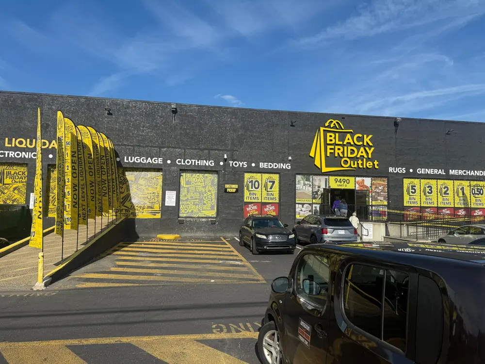 Promotional flags leading customers toward the entrance of a U.S. retail outlet